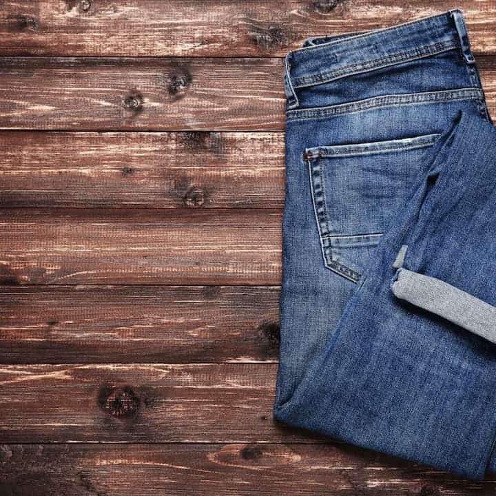 Folded jeans on wooden table