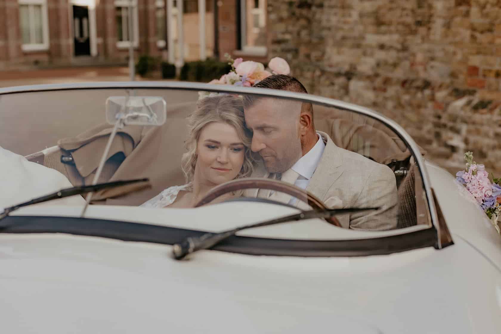 Elegante bruiloftscouple in vintage auto, stijlvolle mannenmode voor heren, trouwjurk en kostuum, chique kleding voor speciale gelegenheden, smart casual herenkleding, trouwpassen en accessoires.